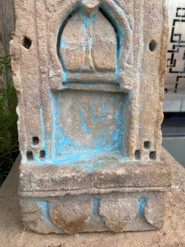 a stone sculpture with blue paint