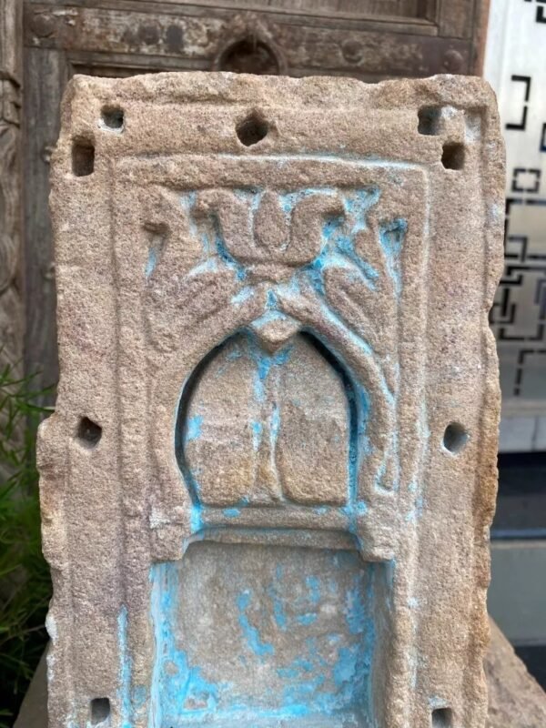 a stone carving of a person with a bird on it