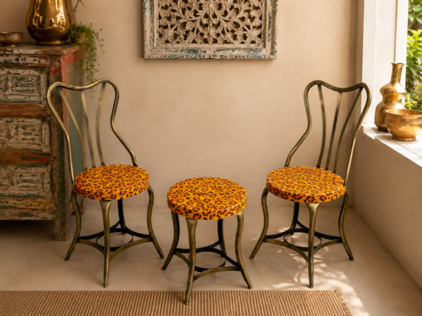 Bring warmth and character to your home with this handcrafted 3-piece bistro set featuring two vintage-inspired iron chairs and a matching round table. Finished in a cheerful antique yellow with intricate hand-painted floral artwork, this eye-catching set combines traditional craftsmanship with timeless elegance, making it perfect for balconies, patios, cafés, gardens, and indoor spaces. Specifications Set Includes: 2 Chairs + 1 Round Table Material: Iron Finish: Antique Yellow with Hand-Painted Floral Design Color: Antique Yellow Style: Vintage / Bohemian / Rustic / Cottage Suitable For: Balcony, Patio, Garden, Café, Bistro, Indoor Seating Condition: Vintage
