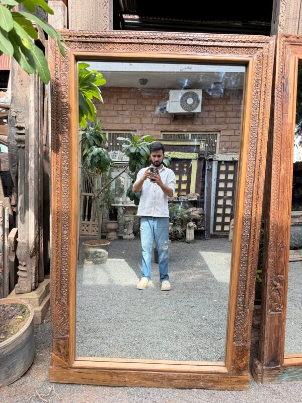 Vintage carved wood floor mirror with floral leaf borders leaning in a living room interior (74 x 43 inches)-collectible vintage